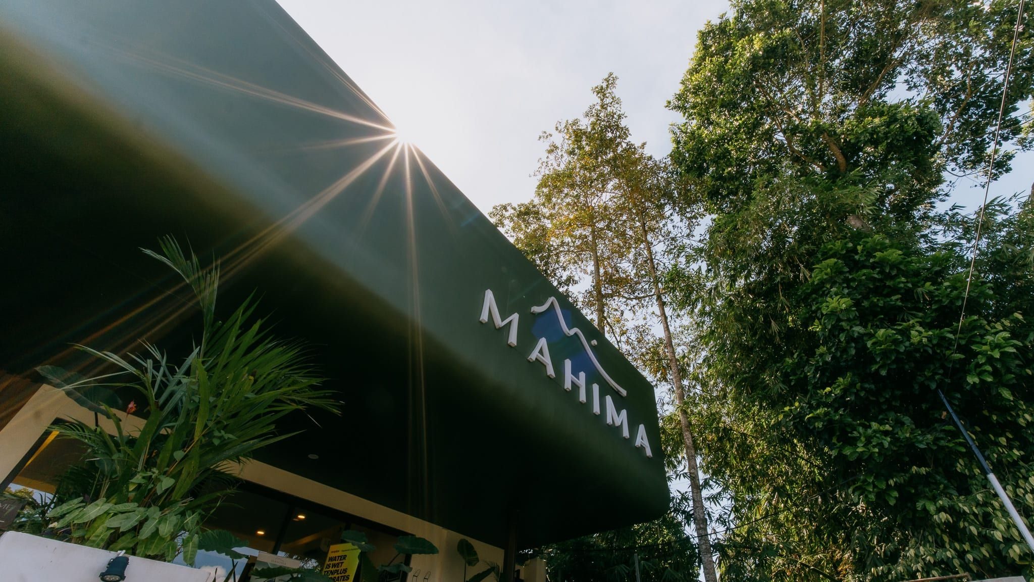 Mahima sign on the clubhouse roof with jungle trees behind