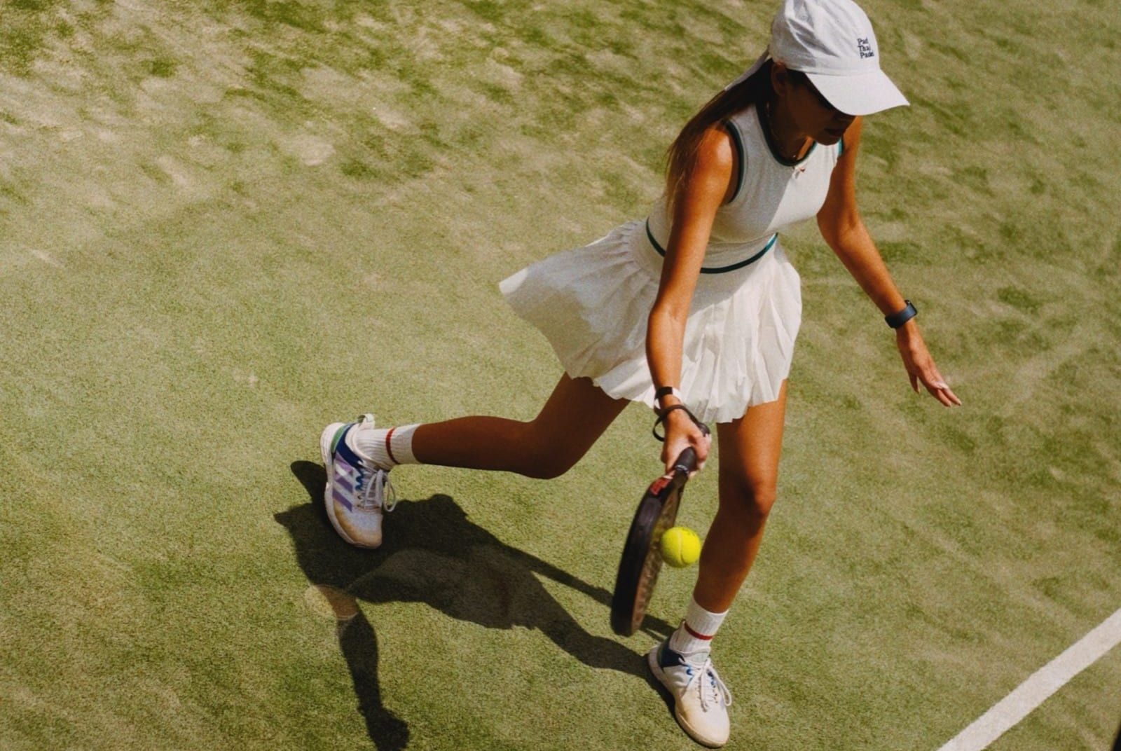 Player hitting a forehand on a green court, seen from above