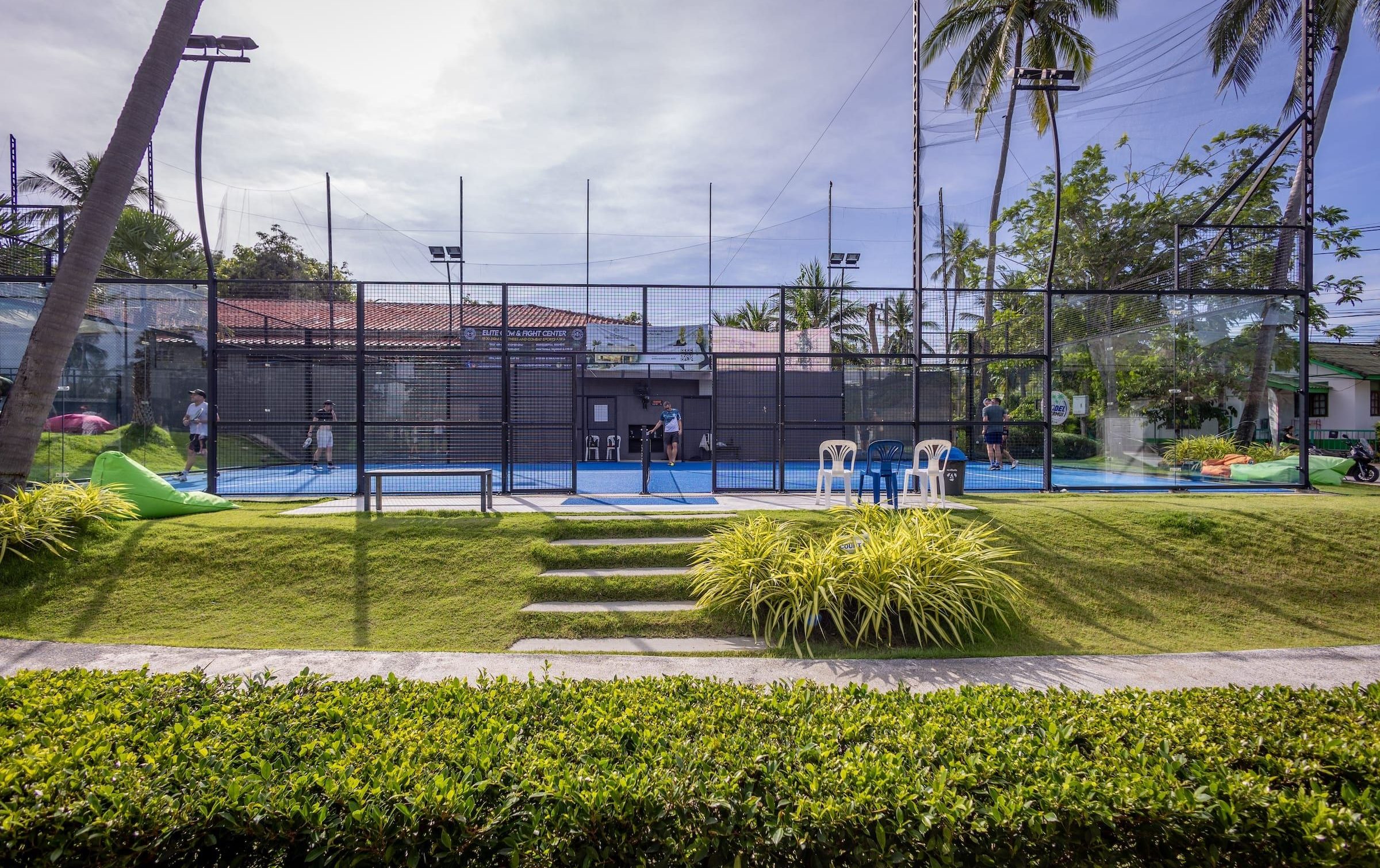 Grass steps leading up to the outdoor courts under palm trees