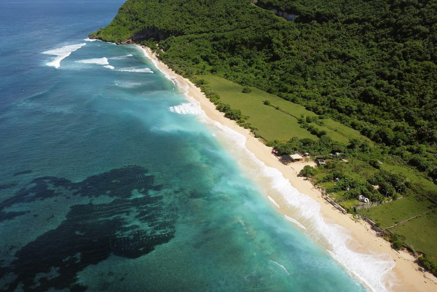 Aerial view of Nyang Nyang Beach: turquoise surf, white sand and jungle-covered cliffs
