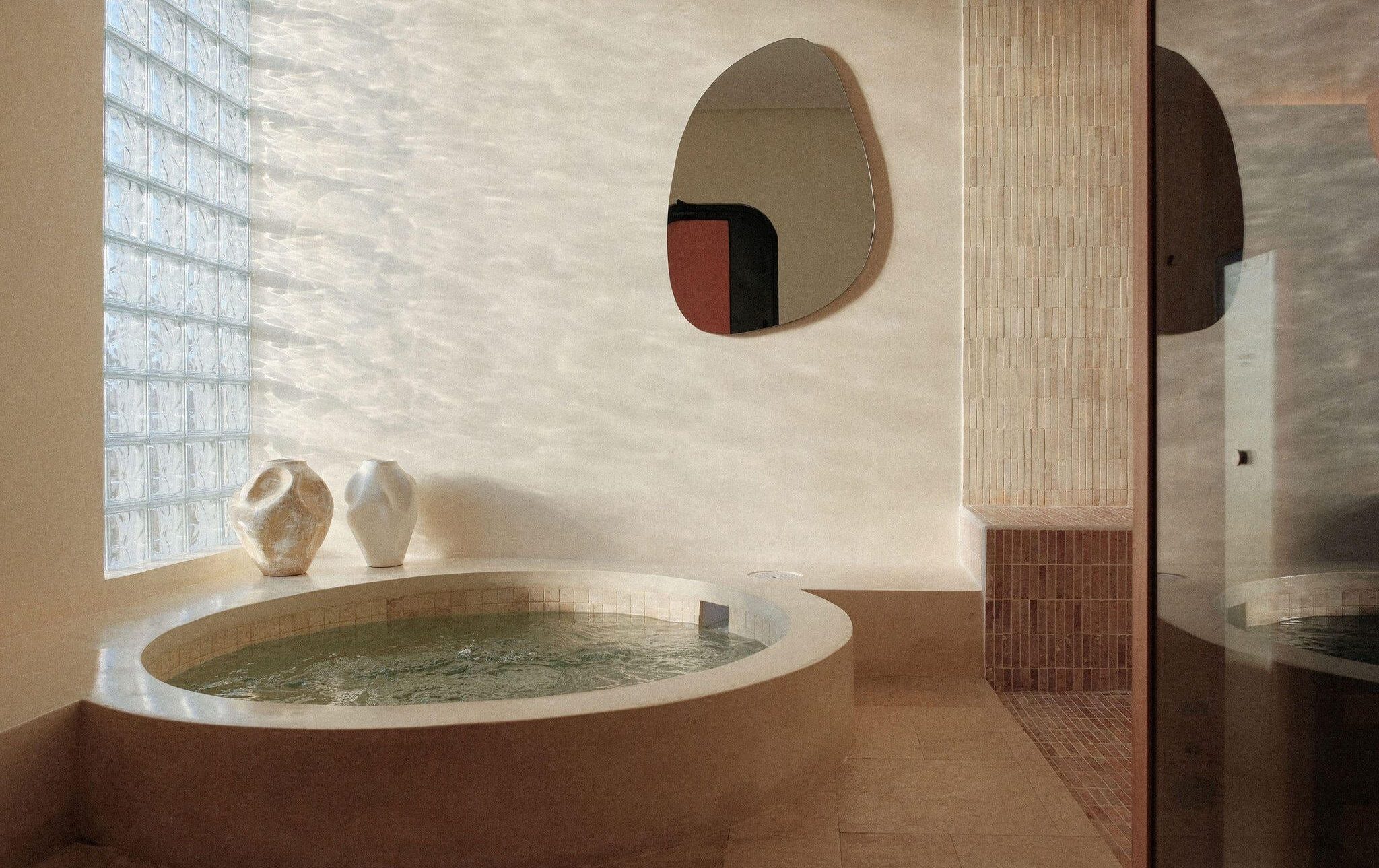 Round stone soaking tub in a softly lit spa room