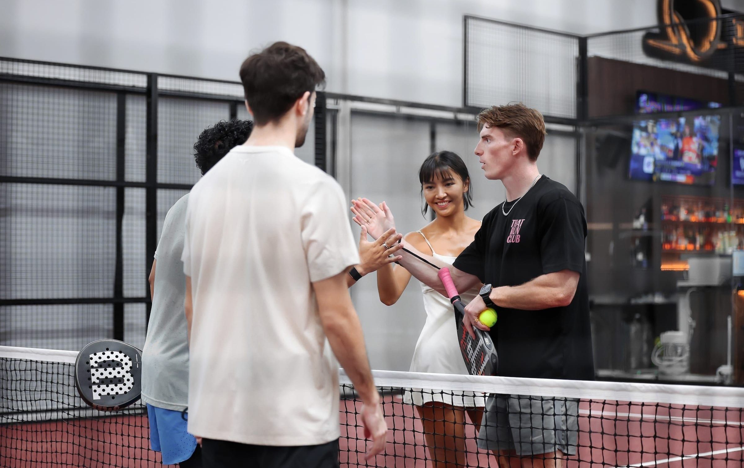 Players high-fiving across the net after a match