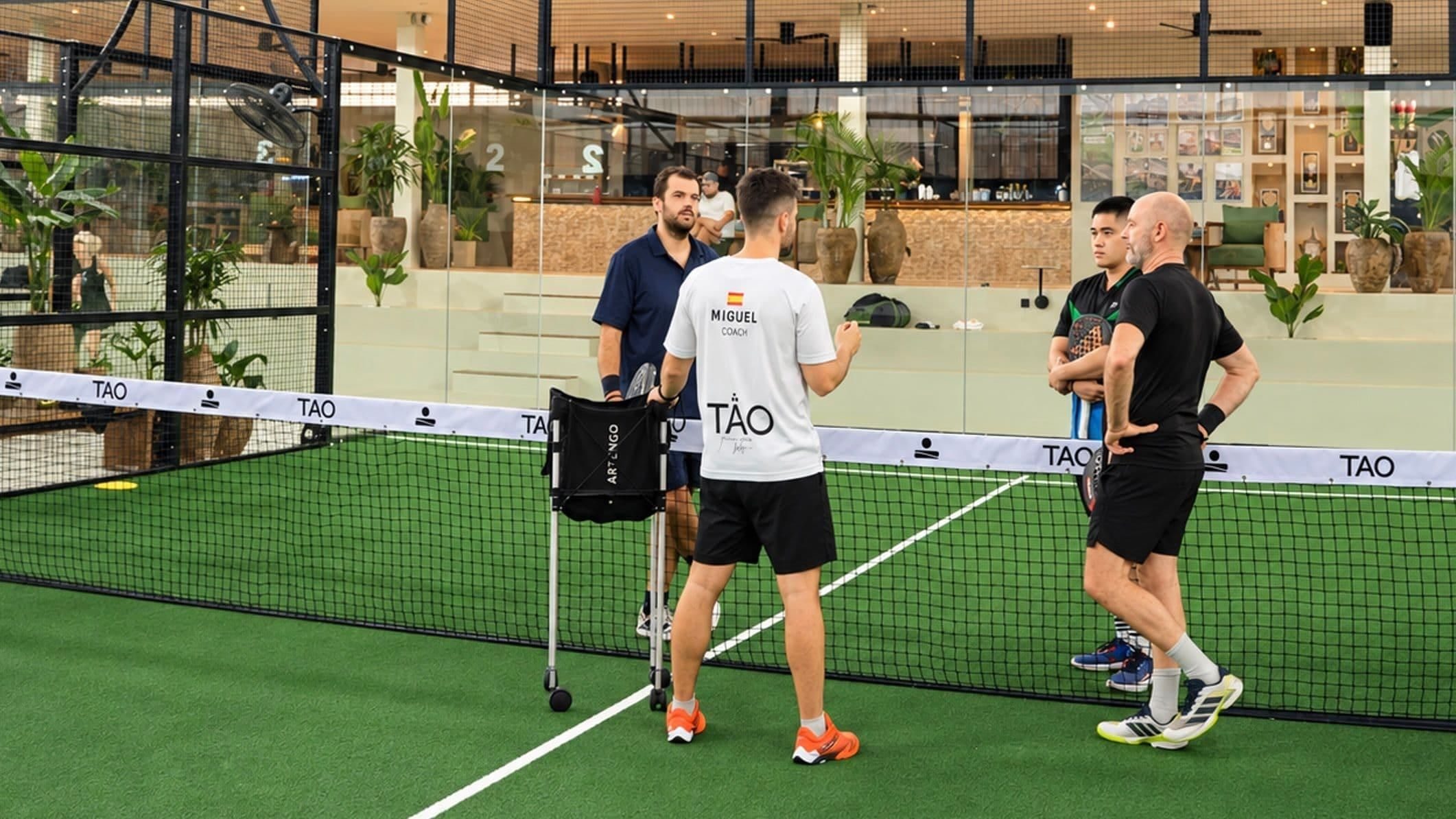 Coaches and players talking by the net on a TAO court